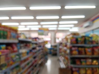 Kasıtlı olarak bulanık bir görüntü, bir süpermarket koridorunun özünü ürün raflarıyla yakalıyor, hareket ya da yumuşak odaklanma hissi veriyor..