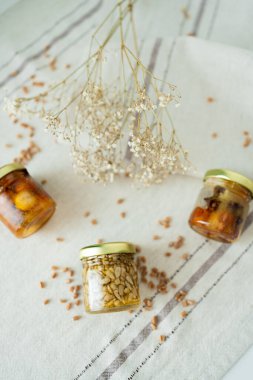 Bal fıstığı kavanozları açık masa örtüsünde çiçek ve buğdayla