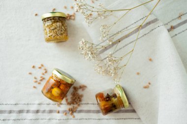 Bal fıstığı kavanozları açık masa örtüsünde çiçek ve buğdayla