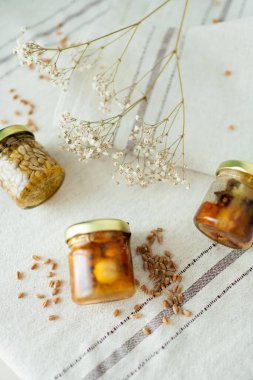 Bal fıstığı kavanozları açık masa örtüsünde çiçek ve buğdayla