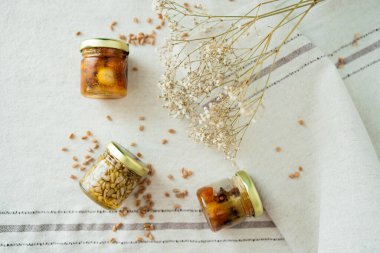 Bal fıstığı kavanozları açık masa örtüsünde çiçek ve buğdayla