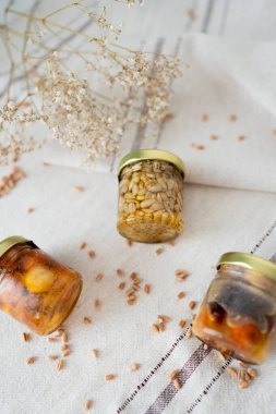 Bal fıstığı kavanozları açık masa örtüsünde çiçek ve buğdayla