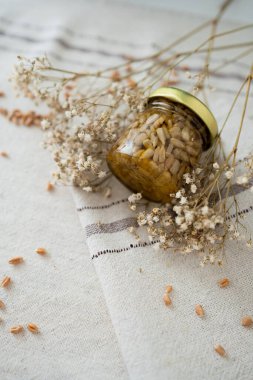 Bal fıstığı kavanozları açık masa örtüsünde çiçek ve buğdayla