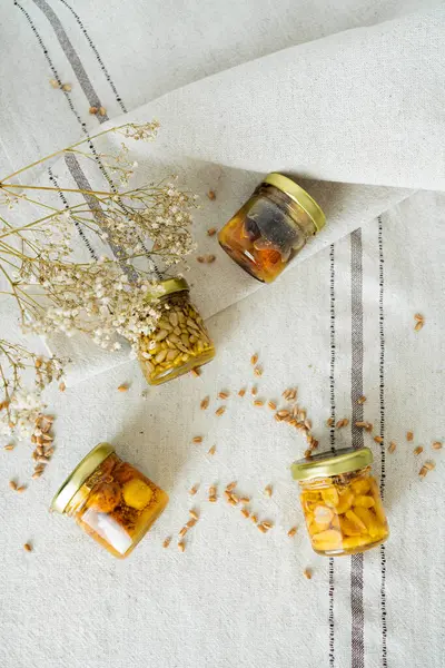 Bal fıstığı kavanozları açık masa örtüsünde çiçek ve buğdayla