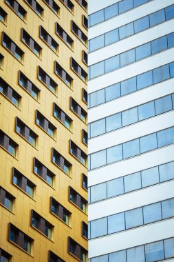 Birbiriyle çakışan iki renkli gökdelen. Çelişkili ve renkli.