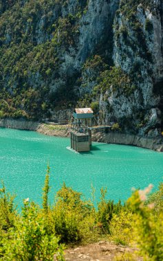 Arnavutluk 'taki Bovilla Gölü barajını koruyan küçük bir binanın manzarası