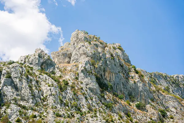 Mavi gökyüzünün altında, güneşin altındaki büyük kayalık dağ..
