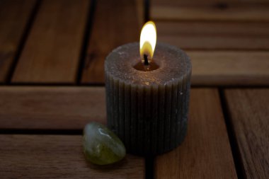 Bir mum sıcak bir ışık yayar ve etrafındaki kurumuş dal ve dallara ışık saçar. Ön planda parlak, yeşilimsi bir taş ya da kristal doğal elementler arasında yer alır. Sahnenin mistik bir yanı var.