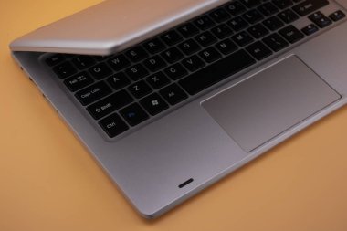 Bej yüzeyinde minimalist klavyesi olan parlak gümüş bir laptop. Yumuşak tonlar ve temiz tasarım şık dijital yaratıcılar için mükemmel, modern bir çalışma alanı yaratır.
