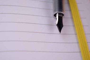 Açık bir günlüğün bu sakin görüntüsü bir dolmakalemle düşünceleri kağıda dökmenin yansımasını, planlamasını ve heyecan verici yolculuğunu davet eder. Yazmak, eğitim ve kişisel gelişim temaları için ideal