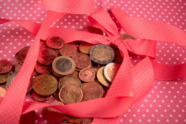 Kırmızı hediye ve bozuk paralarla kırmızı kurdele.