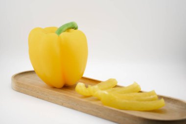 Canlı sarı dolma biber, dilimlere ayrılmış, tazelik, sağlık ve aşçılığa neşeli bir yaklaşım yayıyor. Yemek blogları, sağlıklı beslenme kampanyaları ya da tarif içeriği için idealdir.