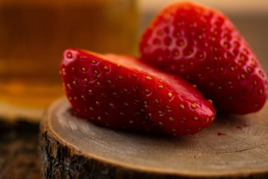 Yakın plan çekimde canlı çileklerin yanında bir bardak yeşil çay, ferahlatıcı bir rahatlık ve doğal tatlılık hissi uyandırıyor. Sağlıklı yaşam, içecek ve yemek blogu içeriği için ideal