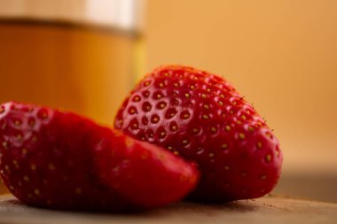 Yakın plan çekimde canlı çileklerin yanında bir bardak yeşil çay, ferahlatıcı bir rahatlık ve doğal tatlılık hissi uyandırıyor. Sağlıklı yaşam, içecek ve yemek blogu içeriği için ideal