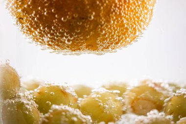 Suda portakallar ve üzümler canlandırıcı ve canlandırıcı bir manzara yaratıyor. Bu görüntü sağlık ve sağlık blogları, meyve suyu barı reklamları veya taze üretim promosyonları için mükemmeldir.