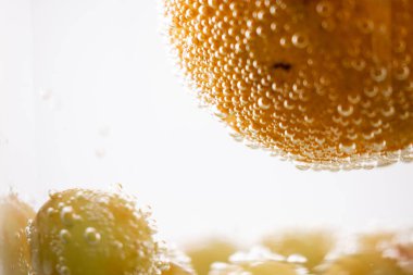 Suda portakallar ve üzümler canlandırıcı ve canlandırıcı bir manzara yaratıyor. Bu görüntü sağlık ve sağlık blogları, meyve suyu barı reklamları veya taze üretim promosyonları için mükemmeldir.