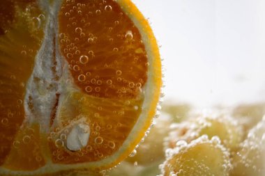 Suda portakallar ve üzümler canlandırıcı ve canlandırıcı bir manzara yaratıyor. Bu görüntü sağlık ve sağlık blogları, meyve suyu barı reklamları veya taze üretim promosyonları için mükemmeldir.