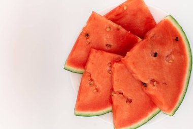  Beyaz arka planda parlak kırmızı karpuz dilimleri, ferahlatıcı tatlılığı ve sağlıklı hoşgörüyü çağrıştırıyor. Yemek blogları, yaz tarifleri ya da sağlıklı yaşam tarzı içeriği için mükemmel.