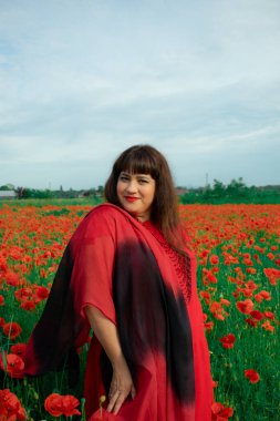 Bir kadın, dalgalı kırmızı ve siyah bir kumaşın üzerinden gizlice bakar. Gizem, cazibe ve doğa ile etkileşim hissini yakalar. Bireysellik ve yaz kaprisleri için idealdir.