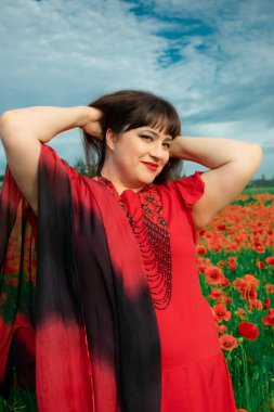 Bir kadın, dalgalı kırmızı ve siyah bir kumaşın üzerinden gizlice bakar. Gizem, cazibe ve doğa ile etkileşim hissini yakalar. Bireysellik ve yaz kaprisleri için idealdir.