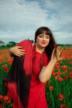 Bir kadın, dalgalı kırmızı ve siyah bir kumaşın üzerinden gizlice bakar. Gizem, cazibe ve doğa ile etkileşim hissini yakalar. Bireysellik ve yaz kaprisleri için idealdir.