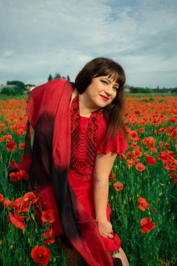 Bir kadın, dalgalı kırmızı ve siyah bir kumaşın üzerinden gizlice bakar. Gizem, cazibe ve doğa ile etkileşim hissini yakalar. Bireysellik ve yaz kaprisleri için idealdir.