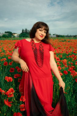 Bir kadın, dalgalı kırmızı ve siyah bir kumaşın üzerinden gizlice bakar. Gizem, cazibe ve doğa ile etkileşim hissini yakalar. Bireysellik ve yaz kaprisleri için idealdir.