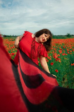 Bir kadın, dalgalı kırmızı ve siyah bir kumaşın üzerinden gizlice bakar. Gizem, cazibe ve doğa ile etkileşim hissini yakalar. Bireysellik ve yaz kaprisleri için idealdir.