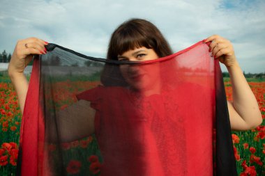 Bir kadın, dalgalı kırmızı ve siyah bir kumaşın üzerinden gizlice bakar. Gizem, cazibe ve doğa ile etkileşim hissini yakalar. Bireysellik ve yaz kaprisleri için idealdir.