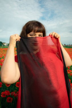 Bir kadın, dalgalı kırmızı ve siyah bir kumaşın üzerinden gizlice bakar. Gizem, cazibe ve doğa ile etkileşim hissini yakalar. Bireysellik ve yaz kaprisleri için idealdir.