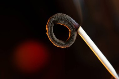 Tütsü çubuğunun ucu, yavaşça parlıyor ve kıvrılıyor, sükuneti davet ediyor. Rahatlama, meditasyon ya da ruhani refah, spa ya da barışçıl sahne görselleri için mükemmel bir tema..