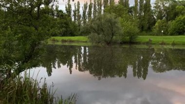 Huzurlu orman gölü, sakin suları etrafındaki ağaçları ve gökyüzünü yansıtır. Doğa veya rahatlama, eko-turizm, açık hava aktiviteleri veya ekolojik içerik, doğal manzara, balıkçılık için idealdir.