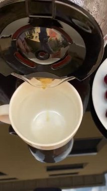 Taze demlenmiş kahve fincana dökülüyor. Sıcak bir içecek hazırlamak için klasik bir an. Sabah rutinleri, molalar ve rahatlatıcı içkiler için mükemmel.