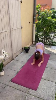 Genç bir kız sabah bahçesinde pijamalarıyla neşeyle jimnastik yapıyor. Bu video gençlik enerjisi, oyuncu hareketler ve güne yeni bir başlangıç kaydediyor..