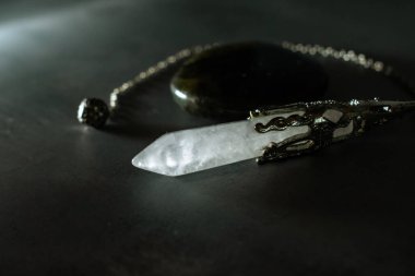 Güçlü bir kristal kuvars sarkacı ve büyüleyici labradorit taşı, somutlaştırıcı ruhani bağlantı, iyileştirici enerji ve kehanet. Gizem ve refah teması için mükemmel..