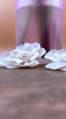 Beyaz kurumuş çiçekli, dikey spa kompozisyonu ve kırsal ahşap üzerinde buzlu difüzyon. Sağlık, doğal güzellik, aromaterapi veya minimalist yaşam tarzı içeriği için idealdir.