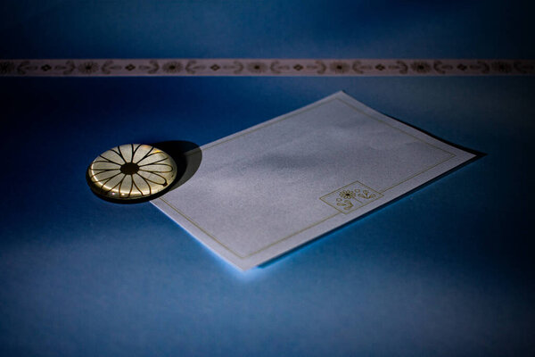 Чистая плоская лежала бланковая открытка с цветочными угловыми акцентами, удерживаемыми элегантными скрепками на синем фоне. Идеально подходит для творческого брендинга, журналирования или объявления шаблонов.