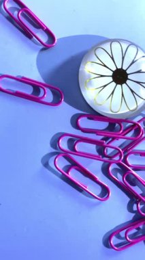 Pürüzsüz mavi bir yüzeye yayılmış renkli ataçlar, raptiyeler ve mıknatıslar eğlenceli ve yaratıcı bir ofis ortamı yaratır. Kırtasiye, organizasyon ve eğitim veya tasarım projeleri için ideal.