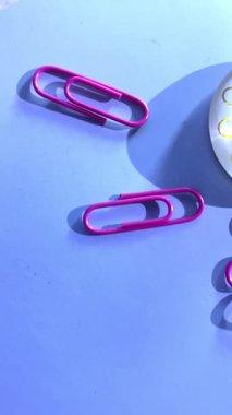 Pürüzsüz mavi bir yüzeye yayılmış renkli ataçlar, raptiyeler ve mıknatıslar eğlenceli ve yaratıcı bir ofis ortamı yaratır. Kırtasiye, organizasyon ve eğitim veya tasarım projeleri için ideal.