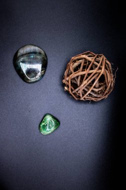 Cilalanmış labradorit ve siyah bir yüzey üzerinde kırsal dal küreli yeşil yeşim taşı. Huzurlu, doğal bir kompozisyon refah, meditasyon ve doğadan esinlenilmiş tasarımlar için idealdir.