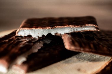 Kırsal ahşap üzerinde kahve çekirdekleri ile çevrili kırık parçalı parlak çikolatalı gofret bisküvileri. Sıcak, rahat atmosfer tatlı ve yaşam tarzı teması için mükemmel..