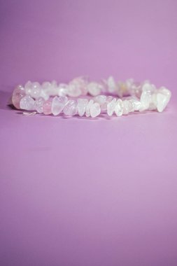 Lavanta arkaplanda kalp şeklinde sıralanmış gül kuvars taşları, aşkı ve huzuru simgeliyor, yumuşak gölgeler kompozisyona derinlik katıyor..