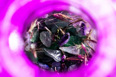 Yeşil bulvar kristalleri, gül kuvarsı ve mor yapraklı cam kavanoz, doğayı, sakin enerjiyi ve ruhsal bağlantıyı simgeliyor..