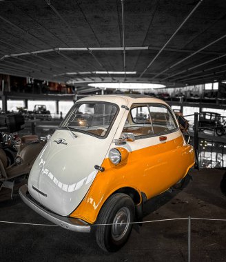 Diğer birçok antika aracın bulunduğu bir odada iki tonluk parlak bir retro araba sergileniyor. Salon sarı ve beyazdır ve karakteristik küçük bir araba şekline sahiptir..