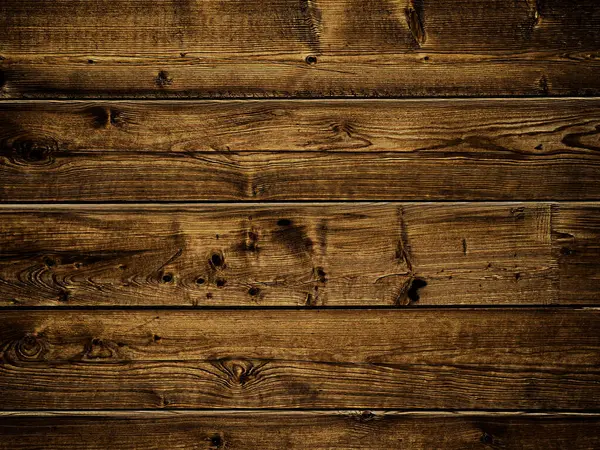 Klasik ahşap arka plan. Yatay olarak yerleştirilmiş koyu kahverengi ahşap kalaslara yakın çekim. Tahtanın görülebilir düğümleri ve tahıl desenleriyle kırsal bir dokusu var..