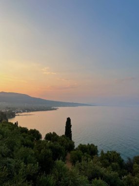 Okyanus üzerinde nefes kesici bir Yunan gün batımı, canlı portakallar ve mor renkler sakin, ışıl ışıl suları yansıtıyor. Yunanistan, Girit 'te günbatımı manzarası çok güzeldir. Yüksek kalite fotoğraf.