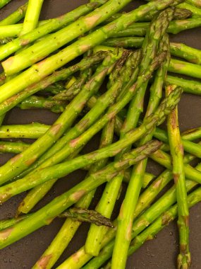 Kuşkonmaz yakın plan. Tavada pişmiş kuşkonmaz. Sebze garnitürünün yakın çekimi..