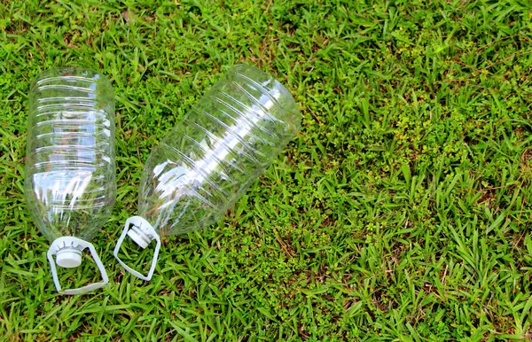 Çöp geri dönüşümü. Çimlerin üzerinde plastik şişeler. Boş plastik su şişeleri.