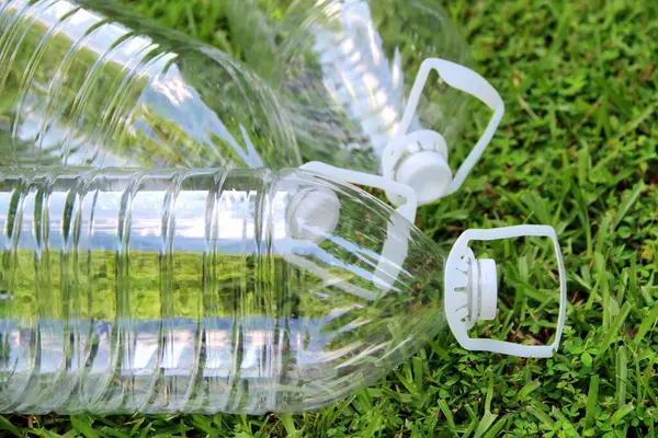 Çimlerin üzerinde plastik şişeler. Geri dönüşüm şişeleri.