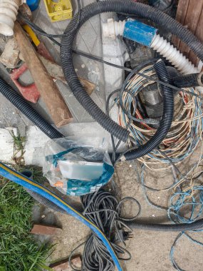Elektrik inşaatı ya da kablolu bakım senaryosu, kıvrımlı borular ve etrafa saçılmış aletler. Teknik ortam kötü bir organizasyon veya kurulum aşamasında.